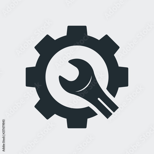 Icono plano engranaje con llave cortada en fondo gris