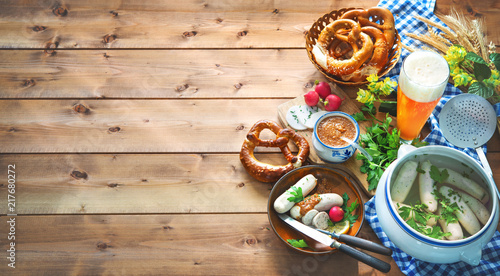 Bavarian sausages with pretzels, sweet mustard and beer on rustic wooden table photo