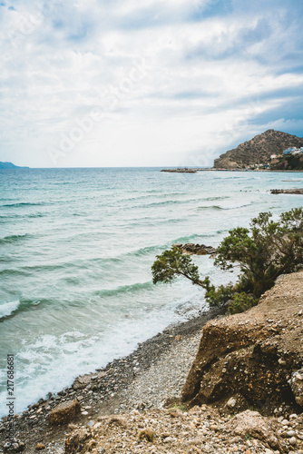 Crete, Greece. beach with rocks and cliffs with view towards sea ovean on a sunny day. photo