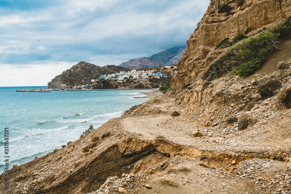 Fototapeta premium Crete, Greece. beach with rocks and cliffs with view towards sea ovean on a sunny day.