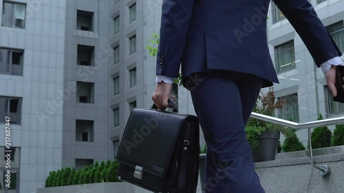 Successful male politician going upstairs with briefcase and phone, businessman