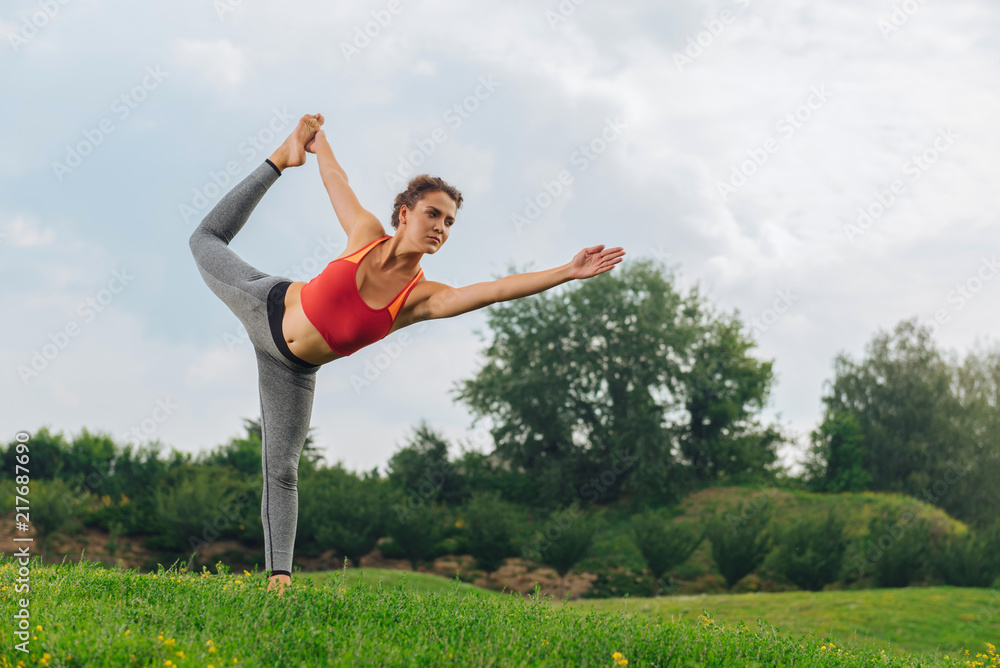 Balancing and stretching. Dark-haired gymnast woman feeling relaxation while improving her balancing and stretching Balancing and stretching. Dark-haired gymnast woman feeling relaxation while improving her balancing and stretching