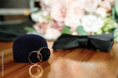Wedding rings with bridegroom butterfly on the wooden floor. Weddig card photo