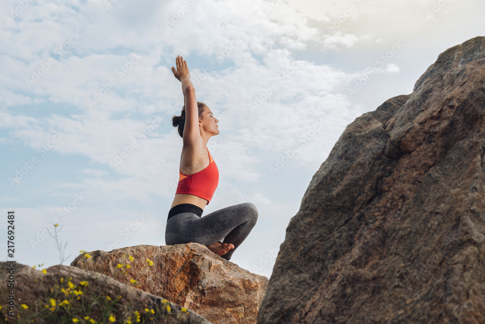 Woman and yoga. Beautiful young woman feeling calm and free while doing yoga sitting on rock Woman and yoga. Beautiful young woman feeling calm and free while doing yoga sitting on rock