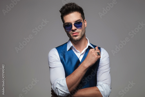 portrait of attractive stylish man wearing blue sunglasses and gilet