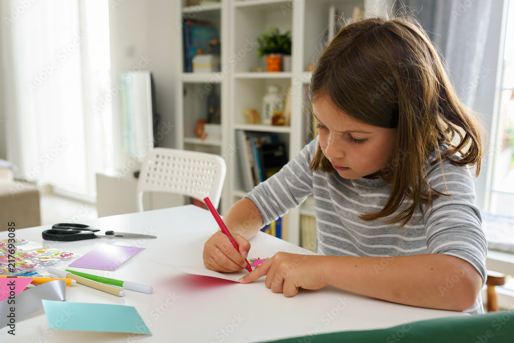 Cute little school girl writing birthday cards Cute little school girl writing birthday cards