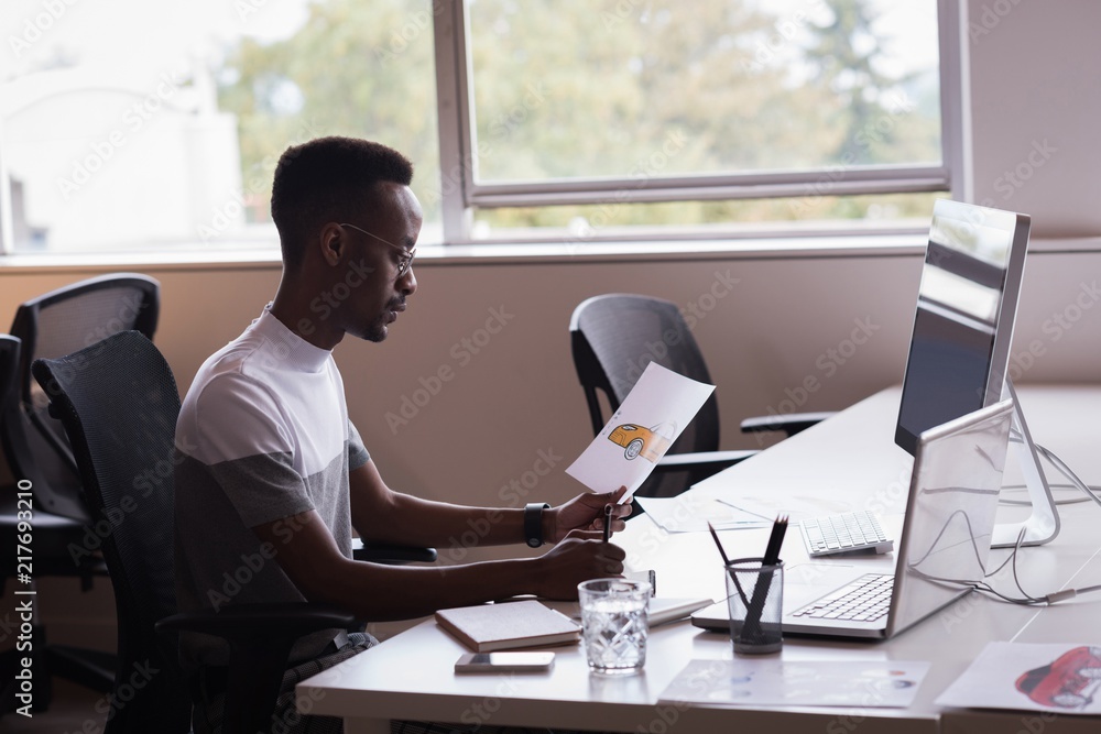 Office executive with drawing of car writing on notepad on his Office executive with drawing of car writing on notepad on his