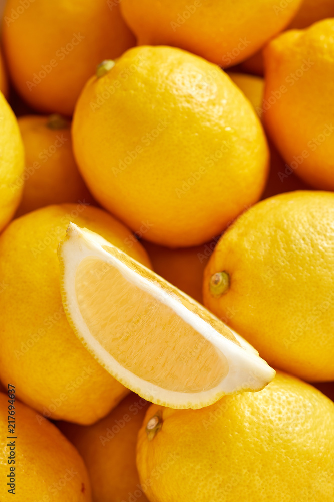 Bunch of fresh lemons in the organic food market. One lemon cutted Bunch of fresh lemons in the organic food market. One lemon cutted