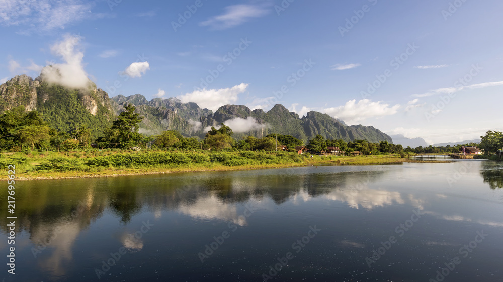 The mountains are reflected in the waters of the Nam Song river in Vang Vieng, Laos