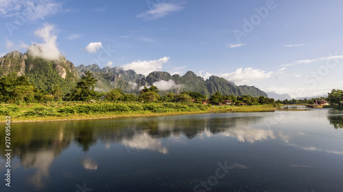 The mountains are reflected in the waters of the Nam Song river in Vang Vieng, Laos