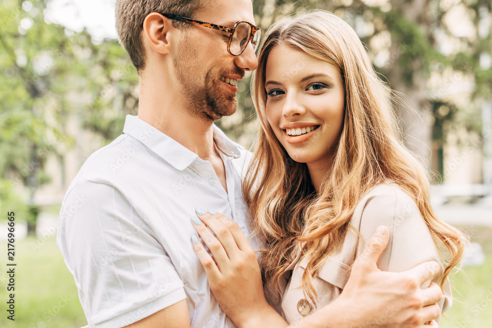 Fototapeta premium bottom view of happy young couple embracing at park