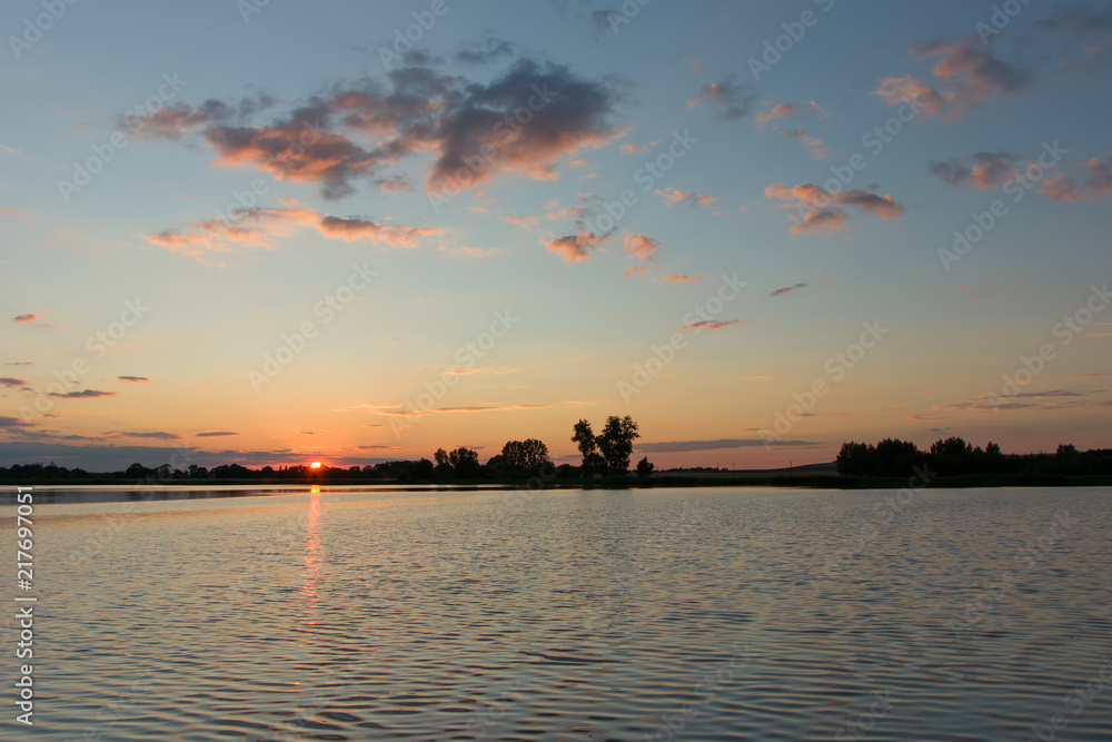 Sunset and clouds in the sky above the lake