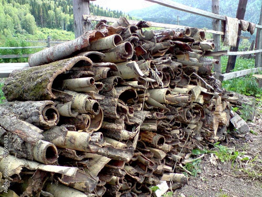 Zavalinka. Rural landscape. The tree bark is stacked at the fence. Zavalinka. Rural landscape. The tree bark is stacked at the fence.