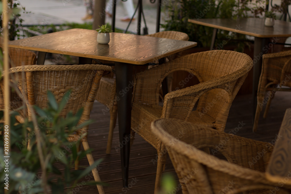 soft focus outdoor cafe patio concept with wooden table and chairs in old city street district 