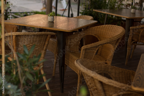 soft focus outdoor cafe patio concept with wooden table and chairs in old city street district 
