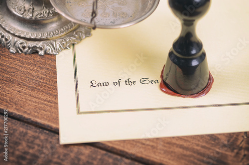 Law of the sea, Scales of Justice and  Notary seal on the wooden background. photo