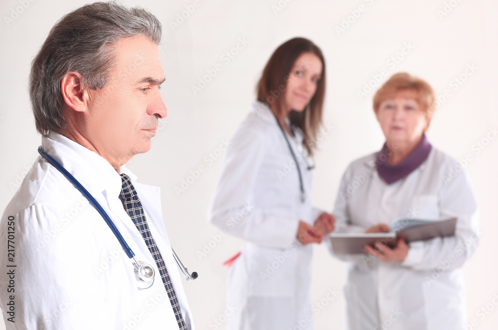 portrait of an experienced doctor in the background of the employees of the medical center portrait of an experienced doctor in the background of the employees of the medical center