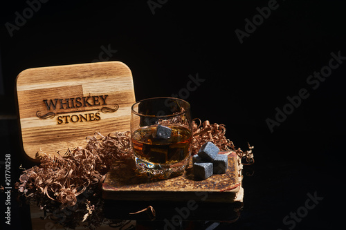 Irish whiskey. Glass of whisky with wiskey stones. Wiskey stones on black background. Elegant glass of whiskey . Whisky stones in wooden box