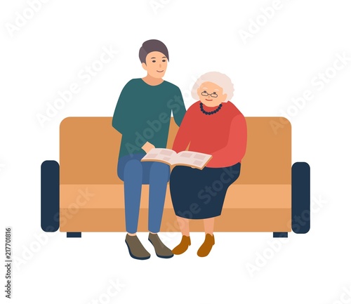 Young male volunteer sitting on sofa with happy elderly woman and reading book. Social volunteering, aid, assistance and care for old people. Colorful vector illustration in flat cartoon style.