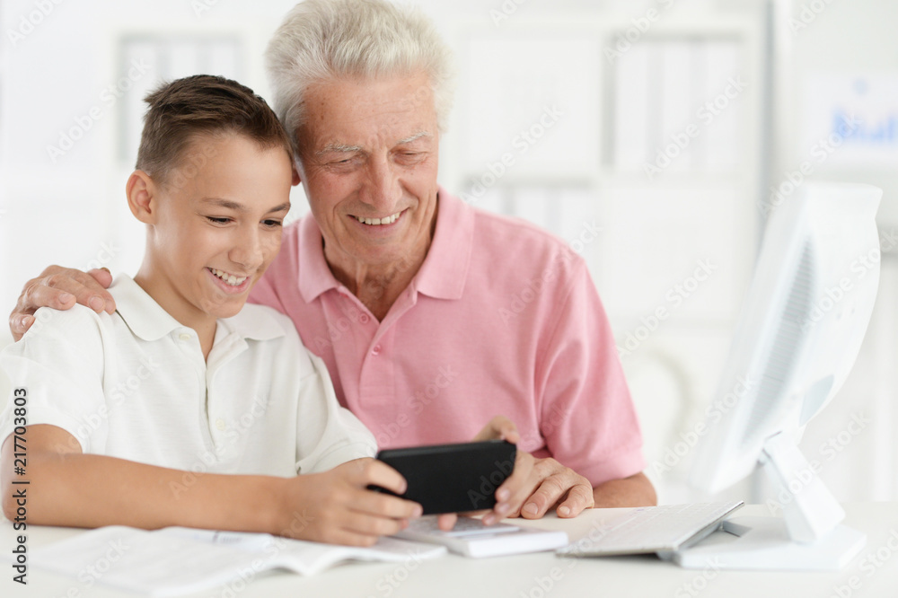 Close up portrait of teenage boy and grandfather Close up portrait of teenage boy and grandfather