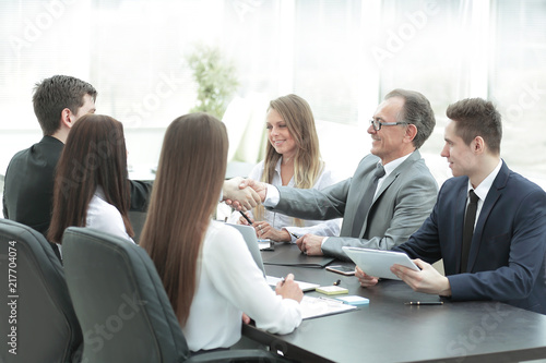handshake of business partners at the negotiating table
