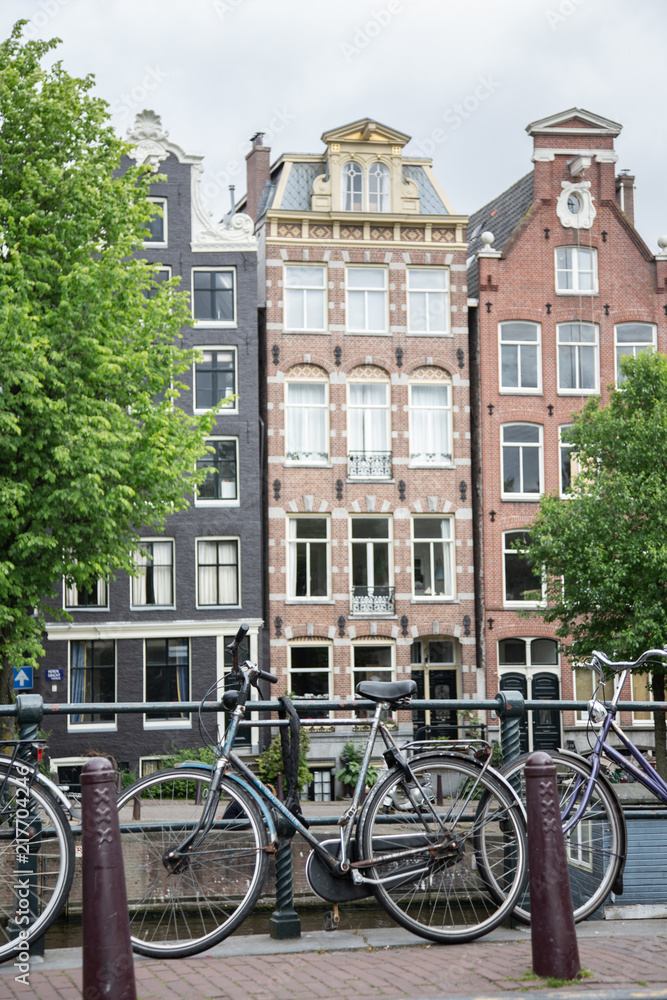 Biciclette in primo piano e palazzi caratteristici di Amsterdam sullo sfondo