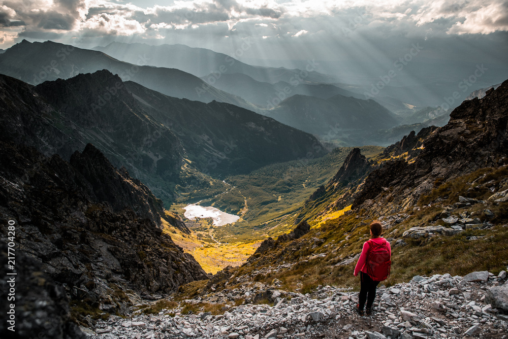 Female Tourist looking to the valley in mountains, beautiful scenery in background