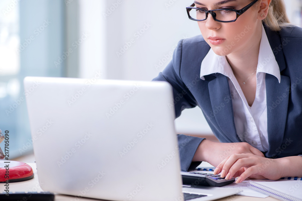 Female finance professional working on keyboard with reports
