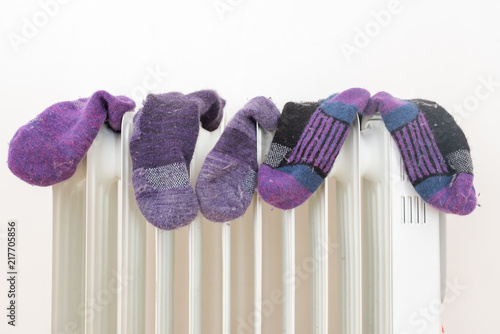 Fotografija Close up of purple and black woollen socks on oil heater - winter concept (selec