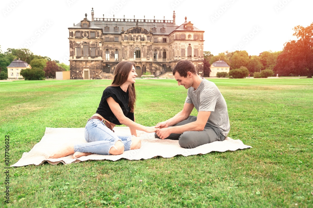 Young couple sitting in front of Historic Building