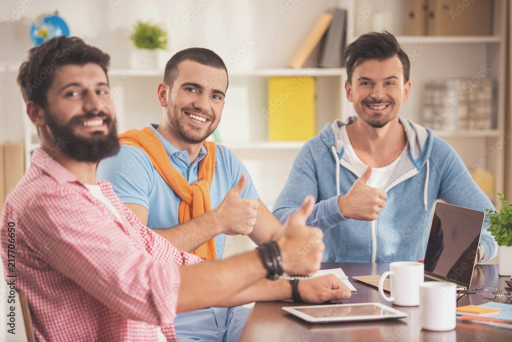 Three Young Smiling Men in Room with Laptop . Three Young Smiling Men in Room with Laptop .