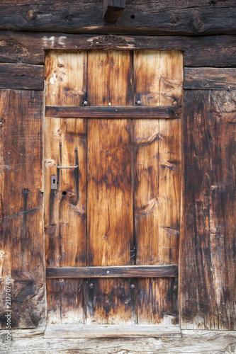 closeup of very old brown wooden weathered planks of door in swiss barn