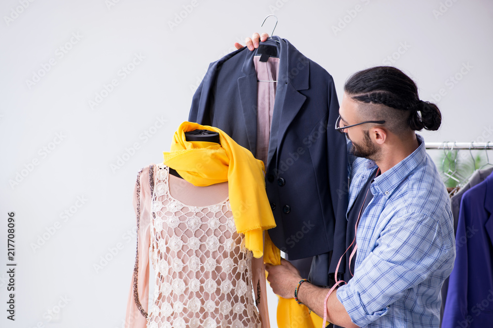 Male tailor working in the workshop on new designs Male tailor working in the workshop on new designs