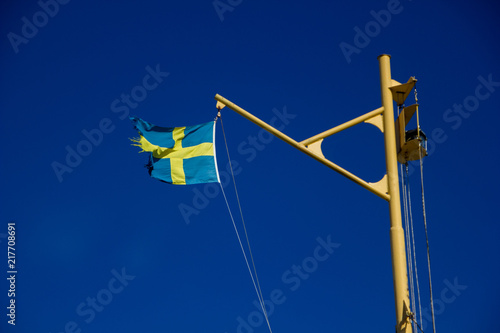 Swedish flag blowing in the wind with blue sky