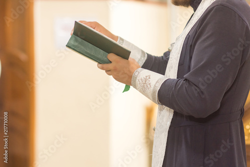 Картината върху платно The hands of the priest hold the bible. the recitation of prayer