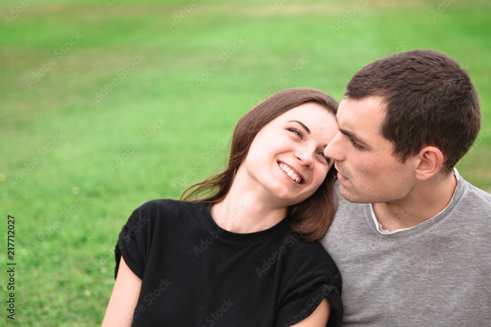 Beautiful couple sit on a blanket on the grass Beautiful couple sit on a blanket on the grass