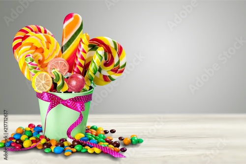 Colorful candies in bucket on white