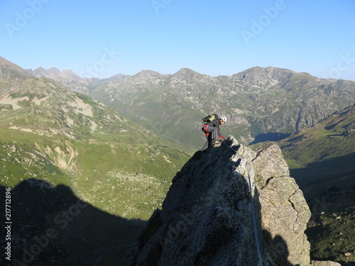 alpiniste casqué en montagne avec corde et en rappel © Ourson+