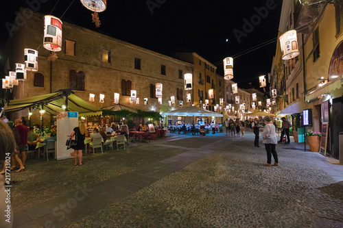Night view of the historic center with the bustling city life of the city of Alghero in Sardinia, Italy. photo