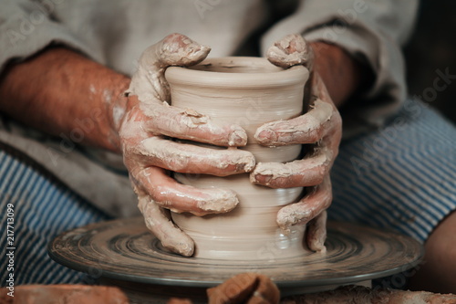 hands of a potter, creating an earthen jar on the circle 