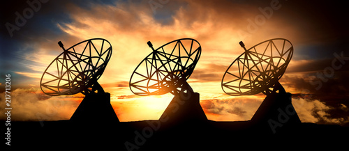 Three satelite dishes over sunset photo