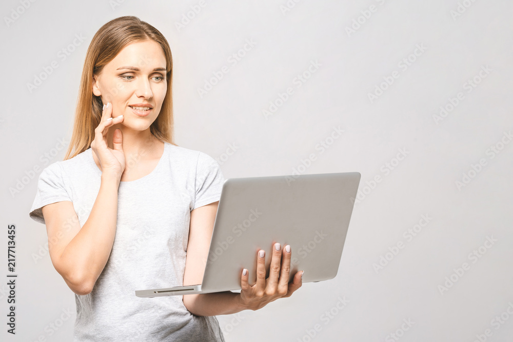 Portrait of happy young beautiful thinking woman standing with laptop isolated on white background. Space for text. Portrait of happy young beautiful thinking woman standing with laptop isolated on white background. Space for text.