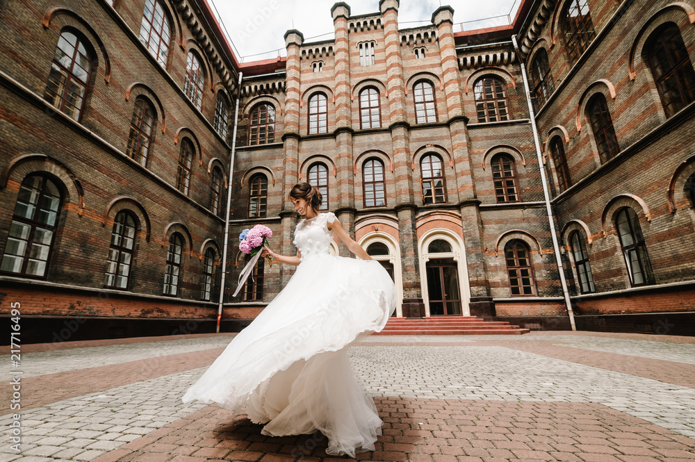 Beautiful portrait bride are dancing and spinning back near ancient restored architecture, old building, old house outside, vintage palace outdoor.