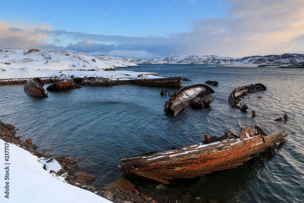 Cemetery of small fishing boats in Teriberke at sunrise. Murmansk region, Russia