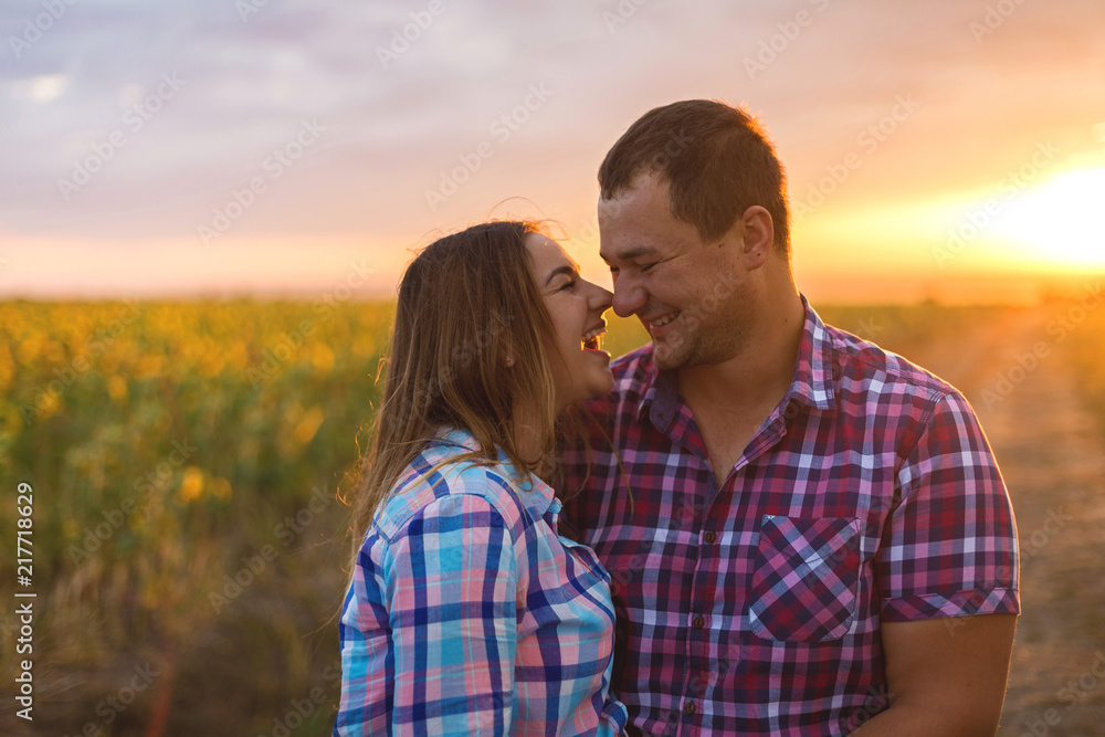 Fototapeta premium Young romantic couple in a field of sunflowers, pregnant girl in sunflowers