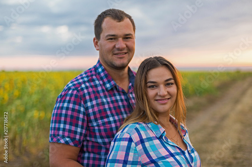 Young romantic couple in a field of sunflowers, pregnant girl in sunflowers