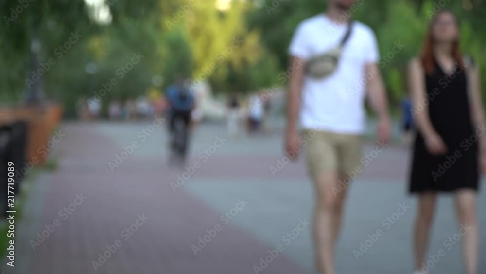 Defocused people, walking on footpath in public park Defocused people, walking on footpath in public park