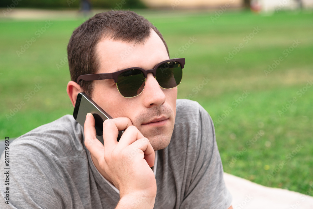 Young handsome man using mobile phone in park Young handsome man using mobile phone in park