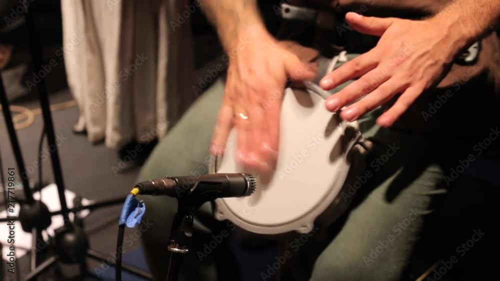 the man plays the drum with his hands the man plays the drum with his hands