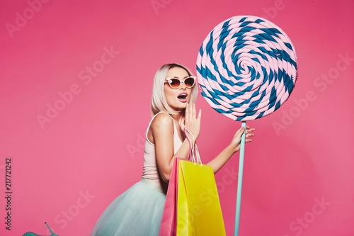 Bilde på lerret Cute model with sweets and shopping bags